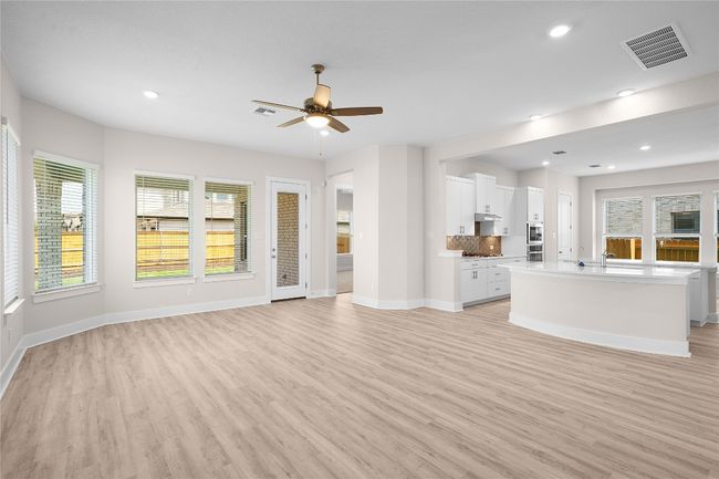 Unfurnished living room featuring light wood-style floors, ceiling fan, baseboards, healthy amount of natural light, and recessed lighting | Image 7