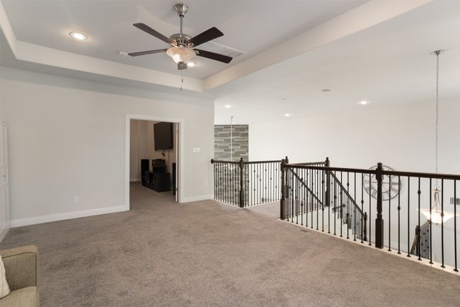 Carpeted empty room featuring baseboards, a ceiling fan, a tray ceiling, and recessed lighting | Image 26