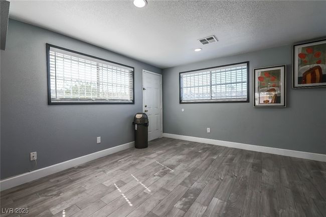 Spare room with a textured ceiling, wood finished floors, baseboards, and recessed lighting | Image 17