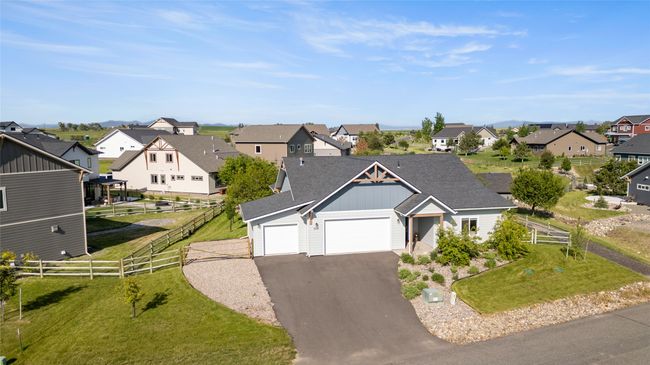 View of front facade featuring a residential view, board and batten siding, a garage, and asphalt driveway | Image 43