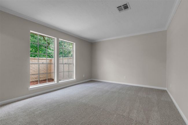 Bright, spacious room with neutral walls and carpet, large windows for natural light, and a clean, modern feel. Ideal for a living area or office space. | Image 8