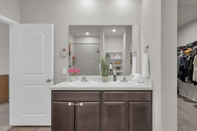 Direct view of the dual sinks for ease of your morning routine. You can get a small glimpse into the primary closet which is very spacious and appealing. Come see it in person! | Image 19