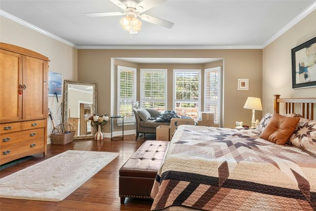 Bedroom featuring ornamental molding, dark wood-style flooring, and ceiling fan | Image 16