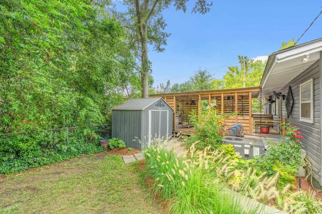 View of yard featuring a storage unit and a wooden deck | Image 29