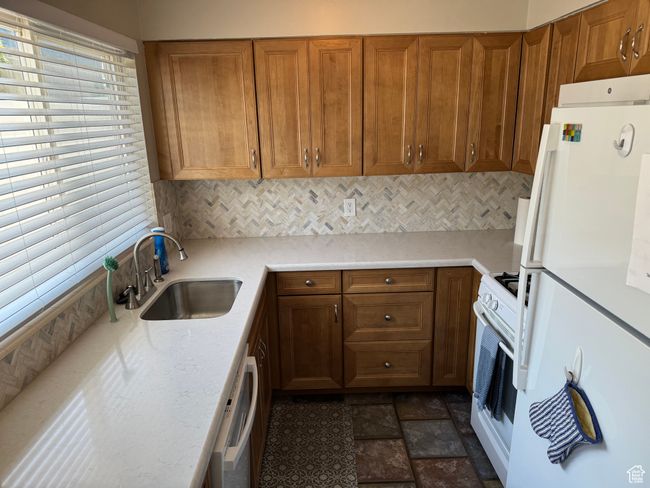 Kitchen featuring white appliances, backsplash, and cabinetry | Image 9