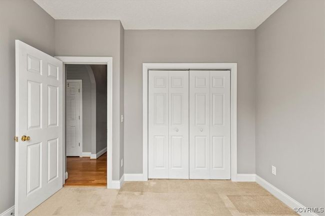 Unfurnished bedroom with light carpet, baseboards, and a closet | Image 37