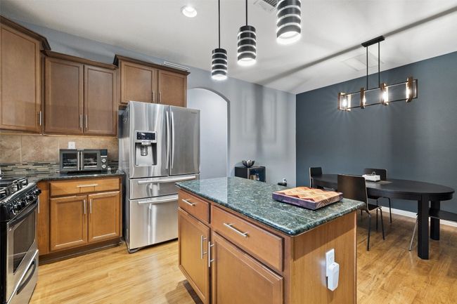 The kitchen boasts granite counters, stainless steel appliances including the refrigerator, center island plus the sink overlooks the back yard. | Image 11