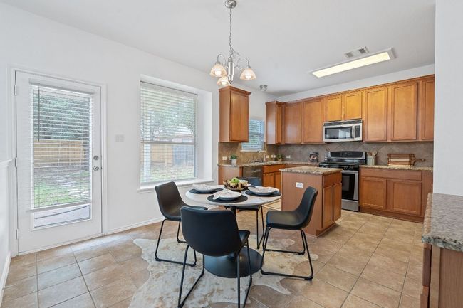 Kitchen featuring appliances with stainless steel finishes, healthy amount of natural light, tasteful backsplash, and a sink | Image 7