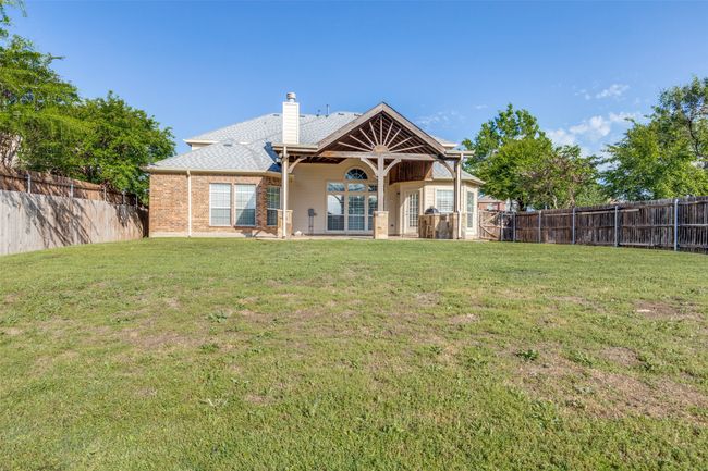 Rear view of house with a lawn, a fenced backyard, and a chimney | Image 25