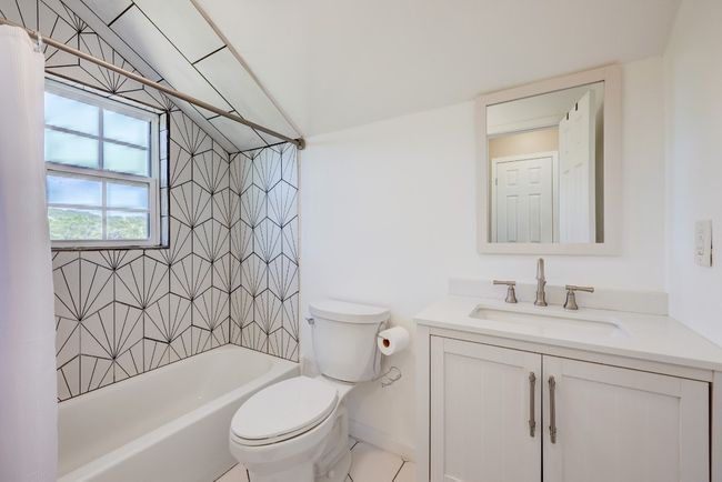 Bathroom with toilet, shower / bathtub combination with curtain, vanity, and vaulted ceiling | Image 11