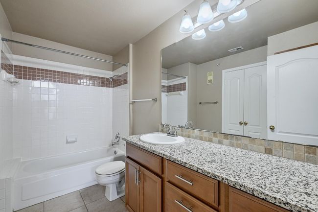 Full bath featuring tub / shower combination, vanity, and tile patterned flooring | Image 19