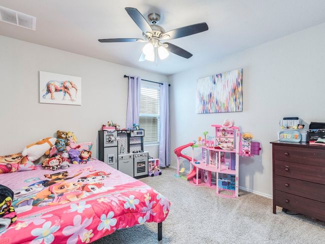 Carpeted bedroom featuring baseboards, visible vents, and ceiling fan | Image 19