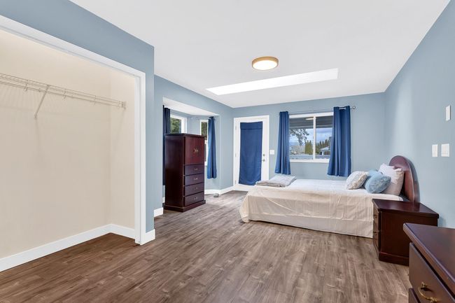 Bedroom featuring dark wood-style flooring, a skylight, and baseboards | Image 11