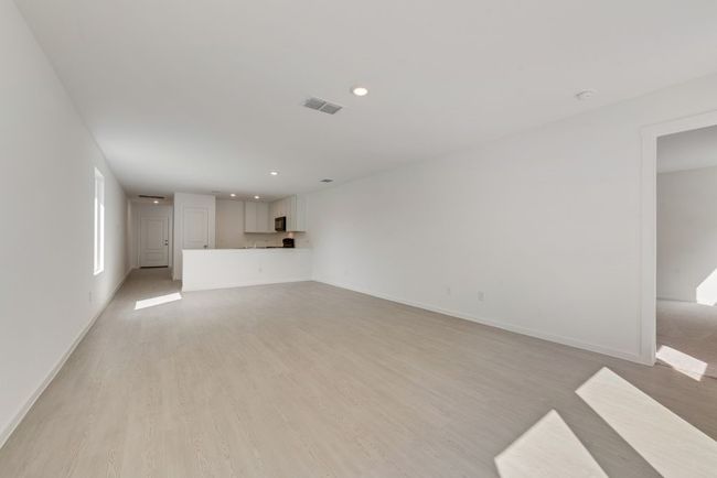 Unfurnished living room with light wood-type flooring and recessed lighting | Image 7