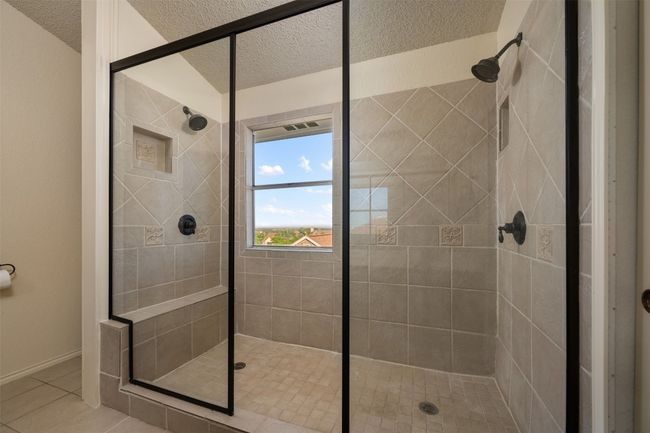 Full bath featuring a shower stall, tile patterned flooring, and a textured ceiling | Image 27