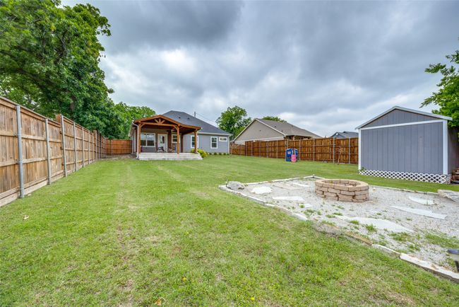 View of yard featuring a fire pit and an outbuilding | Image 12