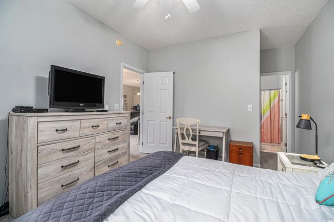 Bedroom with a ceiling fan, multiple closets (including walk-in closet), and an en-suite bathroom. | Image 13