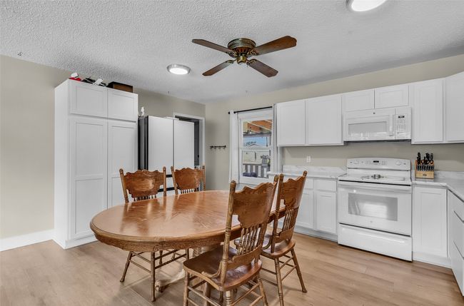 Dining area featuring light wood-style floors, ceiling fan, and a textured ceiling | Image 9