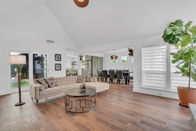 Living area with visible vents, wood finished floors, and high vaulted ceiling | Image 11