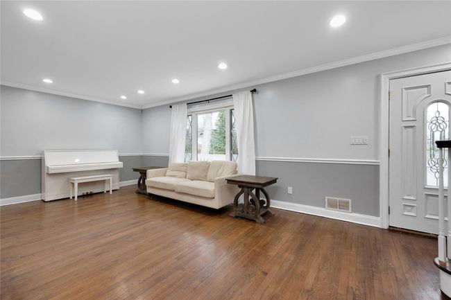 Living area with crown molding, wood-type flooring, baseboards, visible vents, and recessed lighting | Image 4