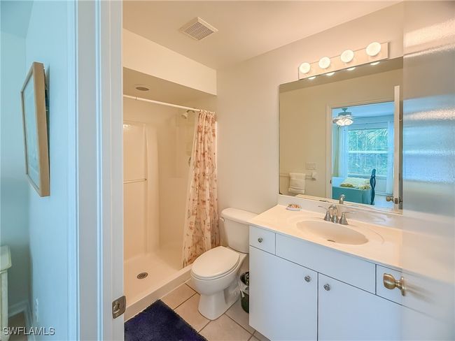 Ensuite bathroom with visible vents, toilet, a stall shower, vanity, and tile patterned floors | Image 40