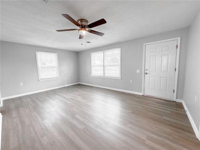 Unfurnished room featuring ceiling fan, a textured ceiling, and hardwood / wood-style flooring | Image 3