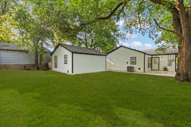 Rear view of house with a yard, central AC unit, a patio, and an outdoor structure | Image 22