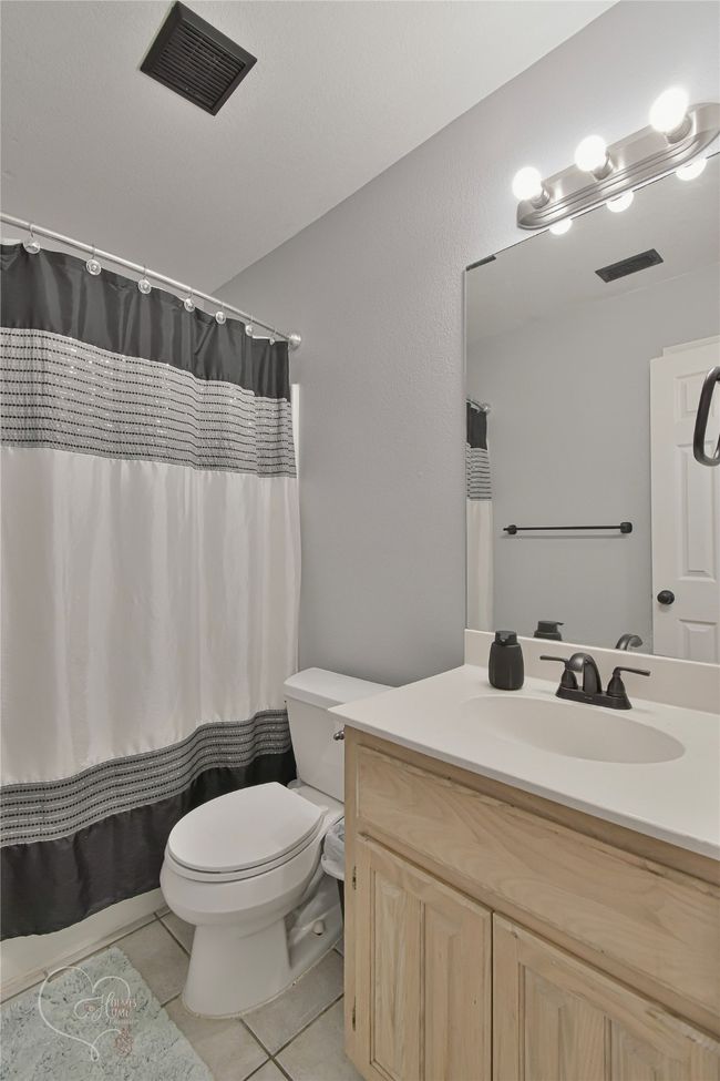 Bathroom featuring tile patterned floors, vanity, and a shower with shower curtain | Image 13