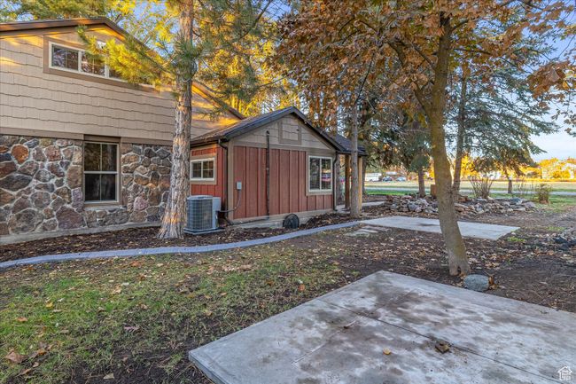 View of front of home with board and batten siding, a patio, and stone siding | Image 12