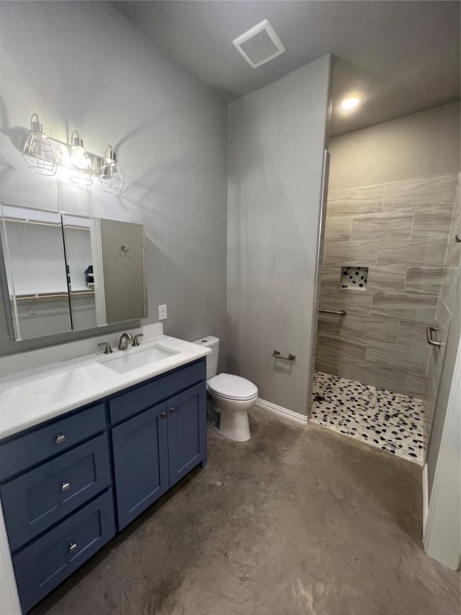 Bathroom featuring vanity, toilet, ADA walk in shower, and concrete floors | Image 30