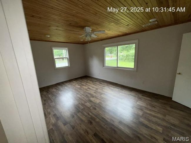 Spare room with wood ceiling, dark wood-type flooring, and a ceiling fan | Image 7