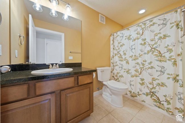 Bathroom featuring tile patterned floors, toilet, vanity, baseboards, and a shower with shower curtain | Image 6