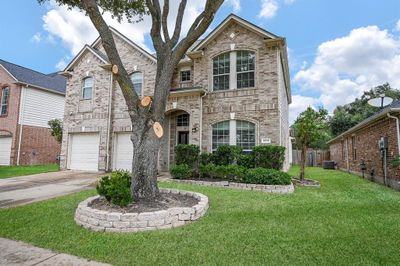 Welcome home! This large home features a two-car garage and mature landscaping for an inviting curb appeal. | Image 1