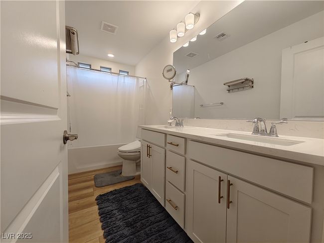 Full bathroom featuring double vanity, toilet, a sink, visible vents, and shower / tub combo | Image 29