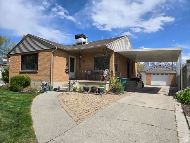View of front of home featuring covered porch, brick siding, an outbuilding, driveway, and a front lawn | Image 41