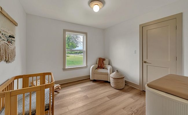 Bedroom featuring light wood-type flooring and a crib | Image 31