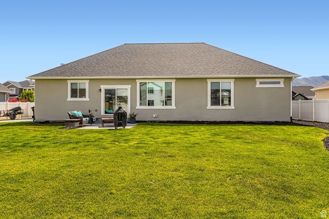 Rear view of property featuring stucco siding, a shingled roof, a patio, and an outdoor hangout area | Image 23