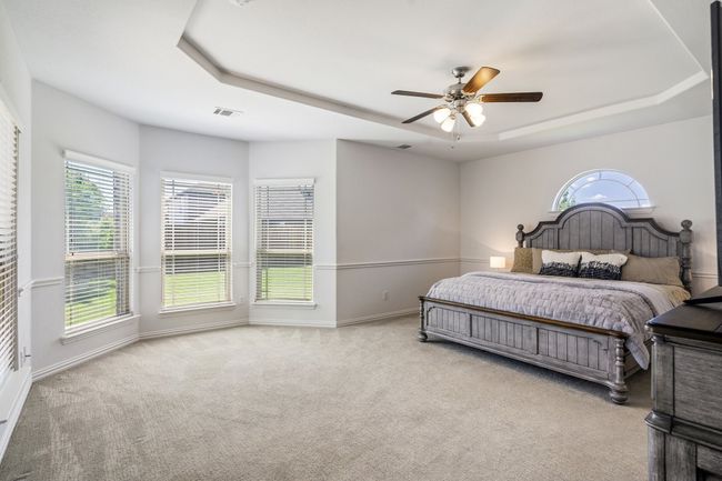 Bedroom featuring a raised ceiling, carpet floors, and ceiling fan | Image 19