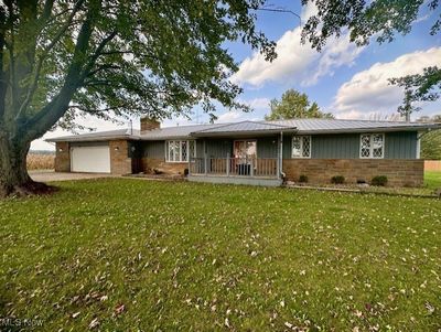 View of front of home with a garage and a front yard | Image 1