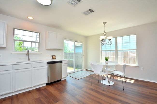 Kitchen with dishwasher, a sink, a chandelier, dark wood-style flooring, and recessed lighting | Image 5