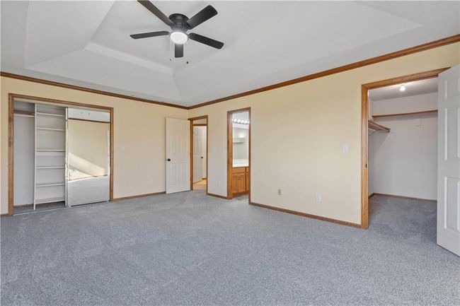 Unfurnished bedroom with a tray ceiling, baseboards, ornamental molding, and carpet floors | Image 25