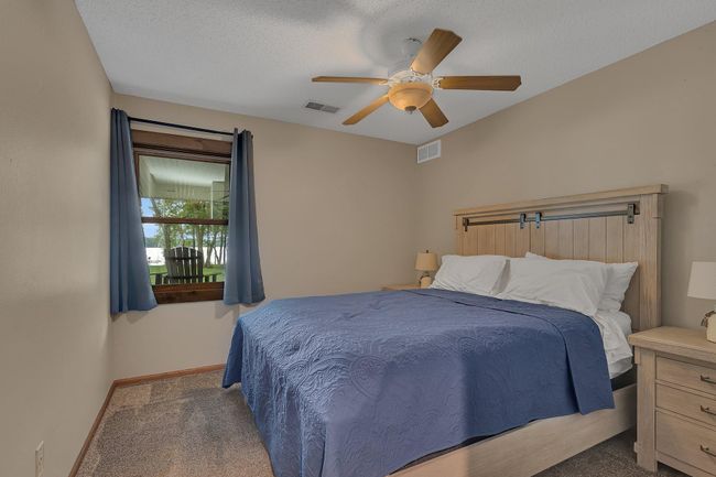 Serene lake views from both lower-level bedrooms, perfect for guests, with natural light and a calming atmosphere. | Image 28