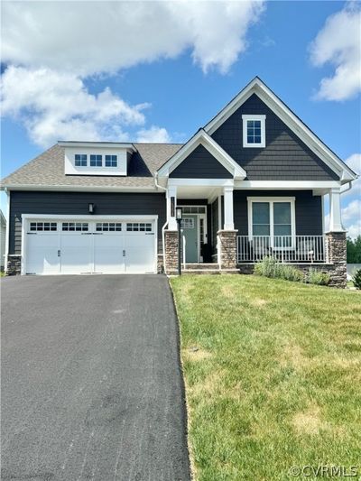 Craftsman inspired home with covered porch, a garage, and a front lawn | Image 1