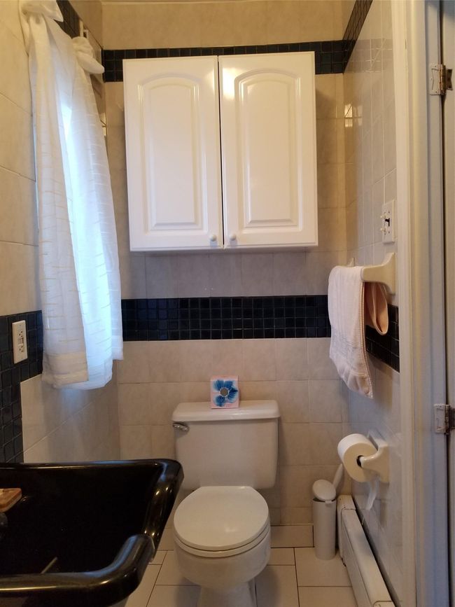 Bathroom with tile patterned flooring, baseboard heating, and tile walls | Image 14