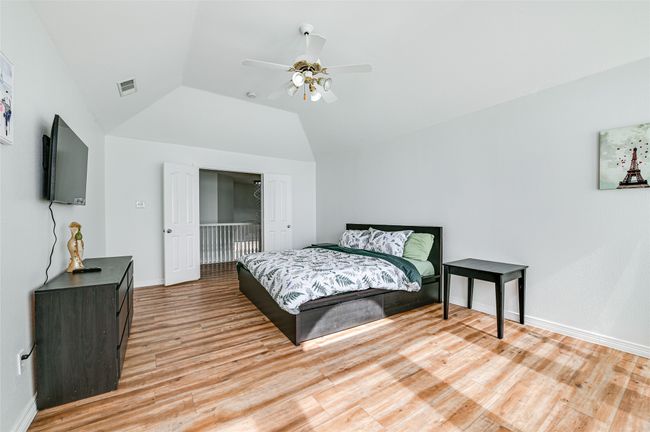 Bedroom with ceiling fan, lofted ceiling, and light wood-type flooring | Image 31