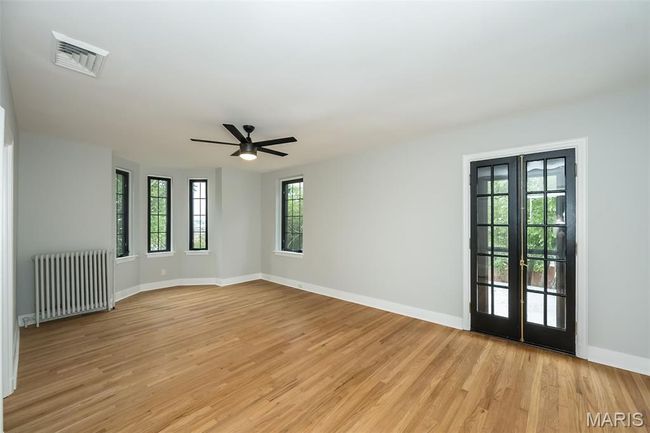 Bedroom 3 with bay window and exterior door leading above the garage. | Image 25