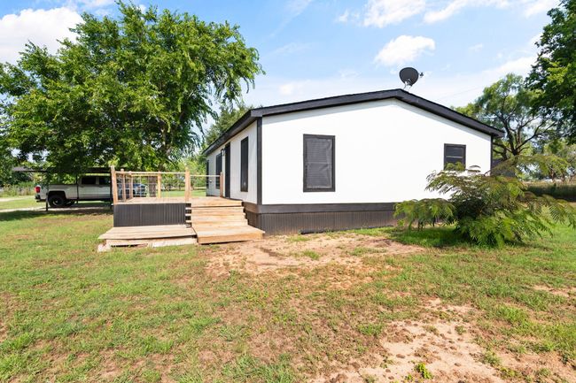 View of home's exterior featuring a wooden deck and a lawn | Image 9