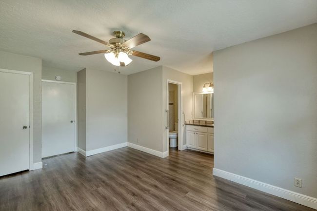Spare room featuring dark wood-style flooring and ceiling fan | Image 7