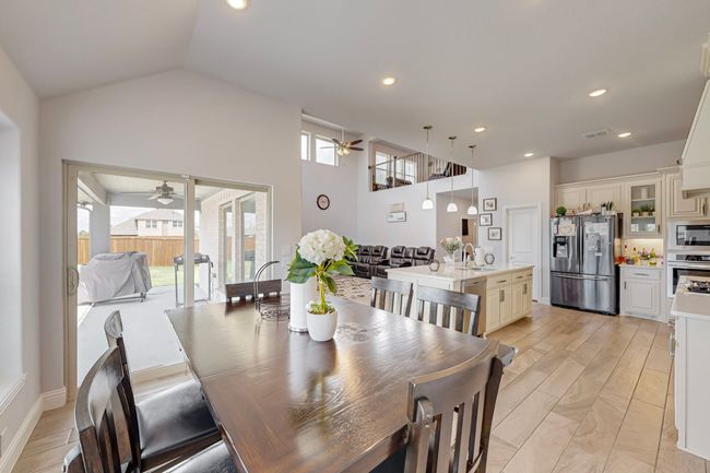 Dining room featuring vaulted ceiling, visible vents, recessed lighting, and a ceiling fan | Image 12