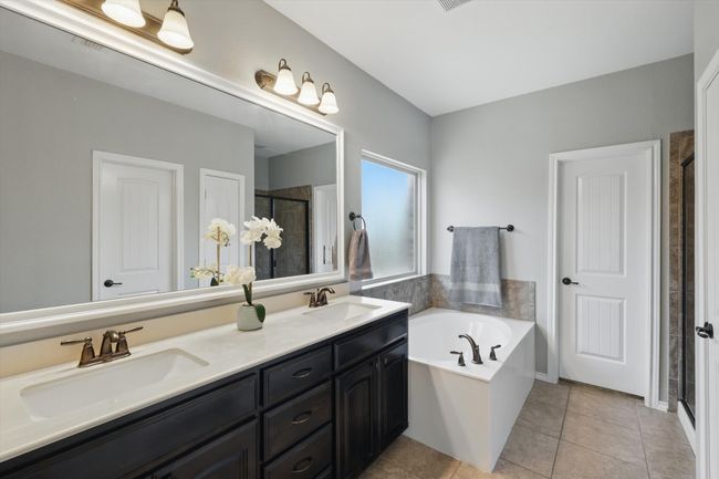 Bathroom with a bath, a stall shower, double vanity, and a sink | Image 19